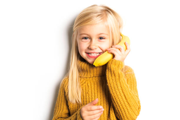 istock A Cute girl 5 year old posing in studio with banana fruit 1069692752