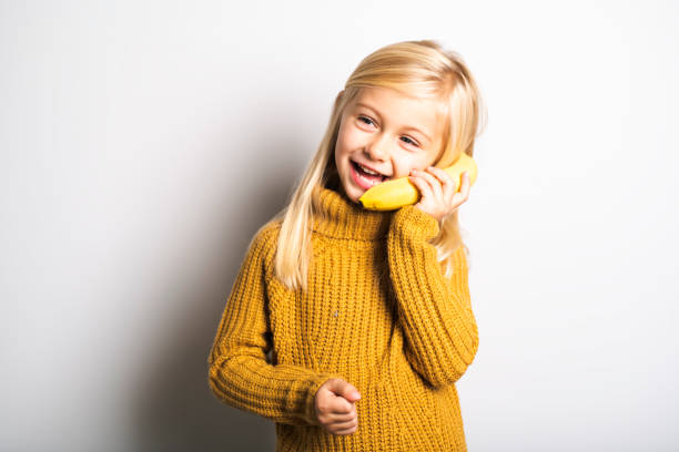 istock A Cute girl 5 year old posing in studio with banana fruit 1069692758