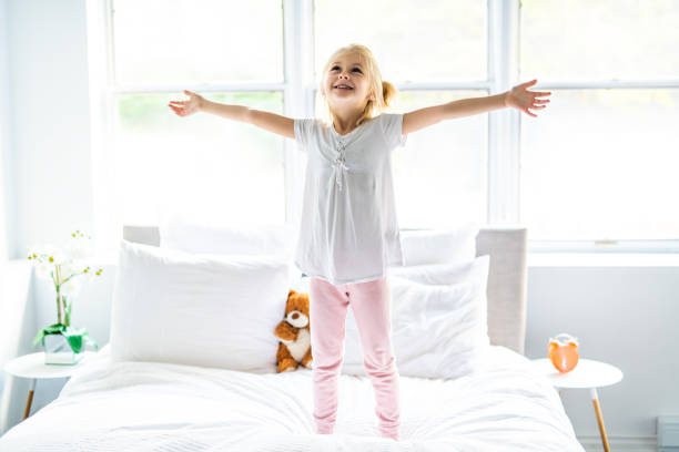 istock A Cheerful little girl in bed having fun 1069693318