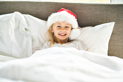 happy funny child girl in bed on Christmas morning