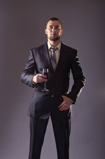 istock Young elegant man in a suit on a gray background. 1069696450