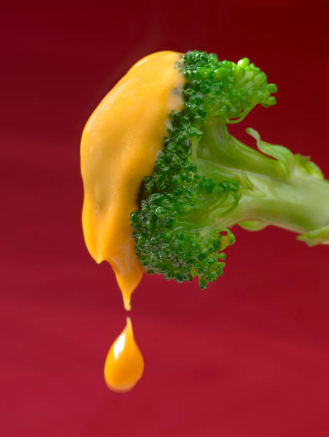 istock Broccoli with yellow Sauce on a red Background 1069701606