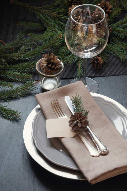 istock Christmas table setting with silverware and dark natural evergreen decor. Top view. Holiday Centerpieces. 1069707146