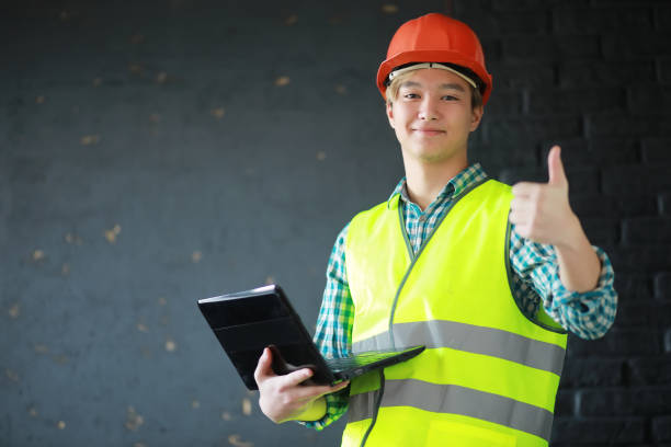 istock Asian man in protective helmet and construction waistcoat 1069709736