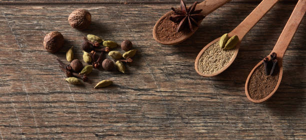 Cardamom, cloves, nutmeg, star anise, allspice. Different types of whole Indian spices in wooden background close-up. Healthy food. Cardamom, cloves, nutmeg, star anise, allspice. Different types of whole Indian spices in wooden background close-up. Healthy food. salt pepper ingredient black peppercorn stock pictures, royalty-free photos & images