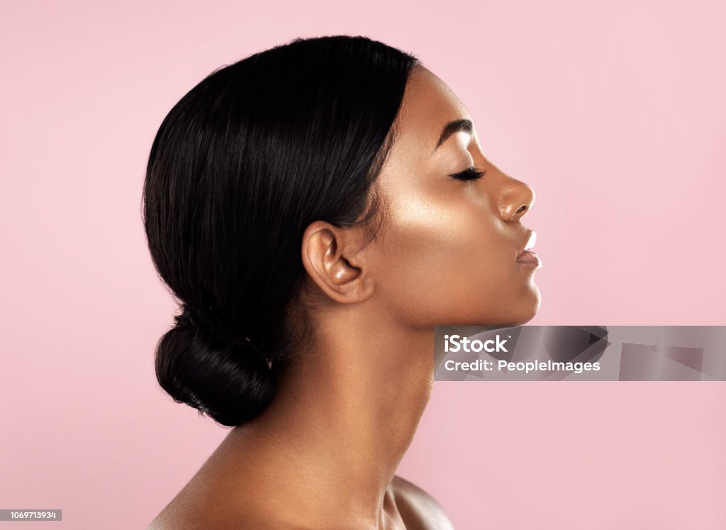 Perfection in profile Studio shot of a beautiful young woman posing with her eyes closed against a pink background Beauty Stock Photo