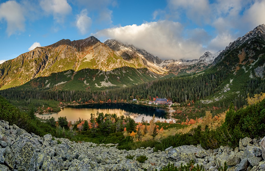 Breathtaking Popradske pleso mountain lake with its reflections Autumn forest, High Tatras in the background