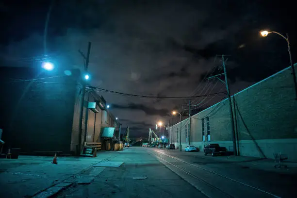 Photo of Industrial urban street city night scene with vintage factory warehouses and train tracks