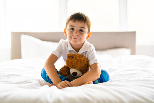 istock A Child sit in bed with a teddy bear 1069718470