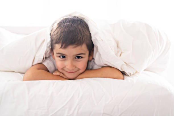 istock A cute four years boy in white bedding 1069718484