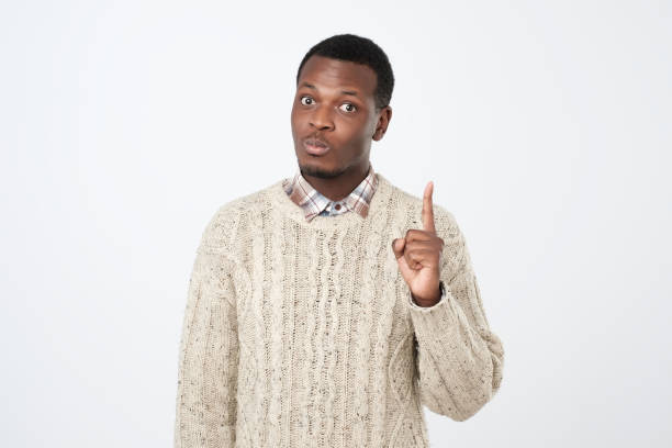istock African young man showing index fingers up, giving advice 1069722442