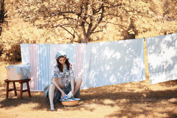 istock Pregnant woman hanging sheets on the rope for drying 1069726526