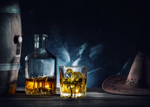 istock Whiskey and cowboy hat on wooden table 1069726764