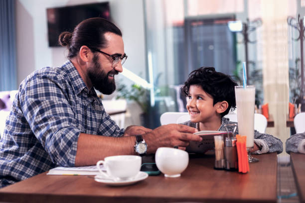 istock Bearded English tutor wearing hand watch showing rules in the book 1069729784