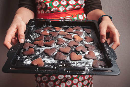 Girl holding baking tray with burnt gingerbread cookies