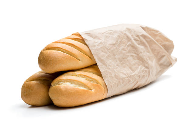 Bread baguettes loafs at a bakery window display on wooden shelf, closeup view