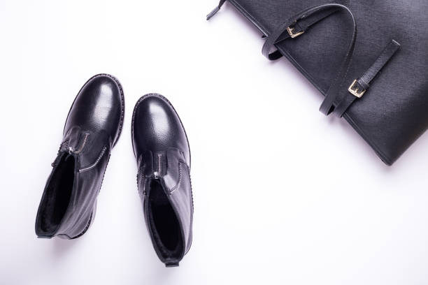 istock Woman accessory. Black stylish boots, black luxury leather bag on white background. Top view. Flat lay. 1069742610