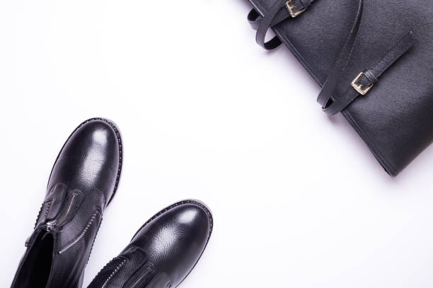 istock Woman accessory. Black stylish boots, black luxury leather bag on white background. Top view. Flat lay. 1069742642