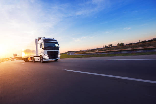 Loaded European truck on motorway in sunset Loaded European truck on motorway in beautiful sunset light. On the road transportation and cargo. landscape photography for sale stock pictures, royalty-free photos & images