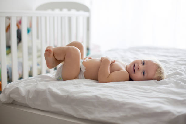 istock Young mom, changing baby diaper after bath 1069744344