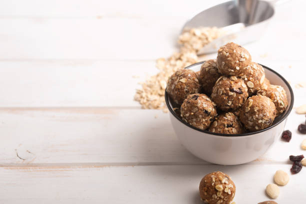 healthy organic energy granola bolls with nuts, cacao, oats and raisins - vegetarian sweet bites without sugar. copy space for text - morder imagens e fotografias de stock