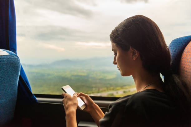 istock Young woman using mobile phone in the bus. 1069745724