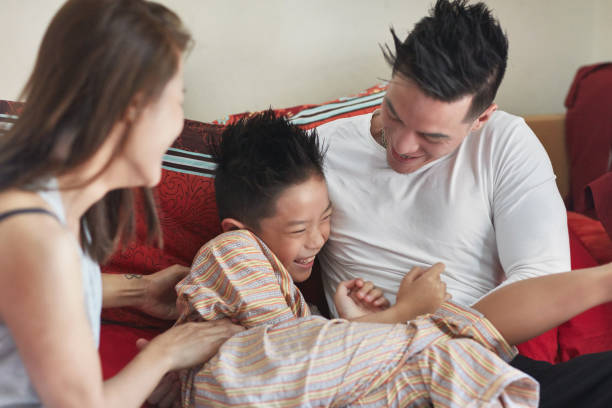 istock Playful family enjoying on bed at home 1069747450