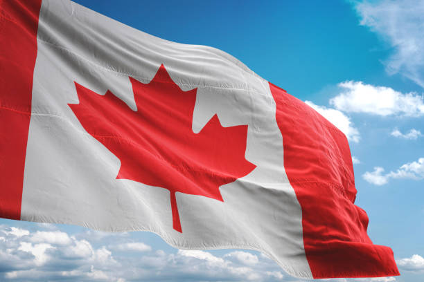 canada flag waving cloudy sky background - canadian flag fotos imagens e fotografias de stock