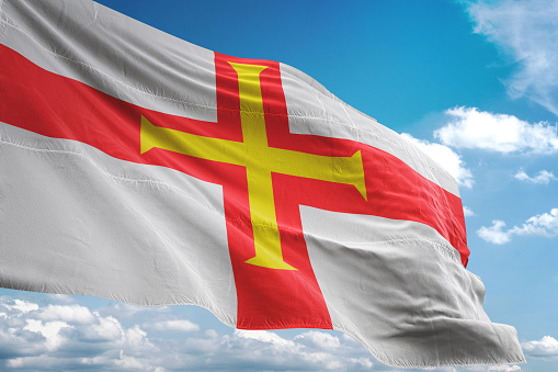 Guernsey flag waving cloudy sky background realistic 3d illustration