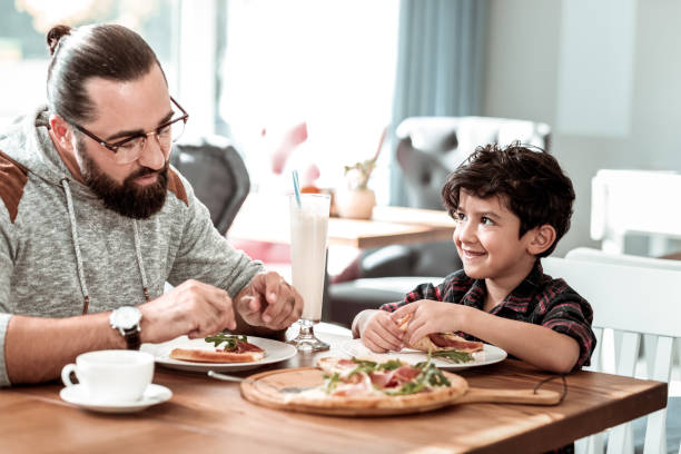 istock Father and son eating extremely yummy pizza with bacon and cheese 1069753238