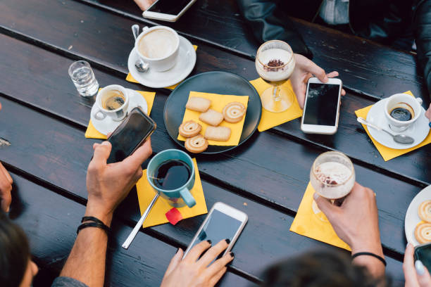 istock Group of friends using mobile devices during breakfast outdoor 1069753472