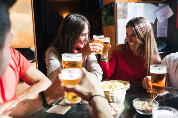 group of happy friends drinking beer at the brewery - irish culture beer drinking pub imagens e fotografias de stock