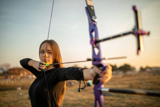 adolescente en el entrenamiento de tiro con arco al atardecer - tiro con arco fotografías e imágenes de stock