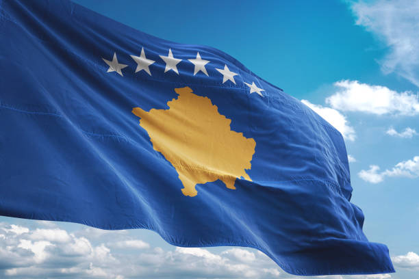 istock Kosovo flag waving cloudy sky background 1069755106