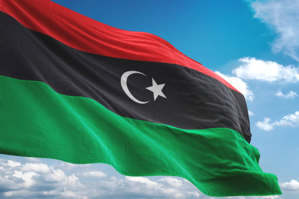 bandera libia ondeando fondo cielo nublado - libyan flag fotografías e imágenes de stock