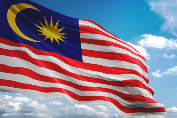 istock Malaysia flag waving cloudy sky background 1069756374