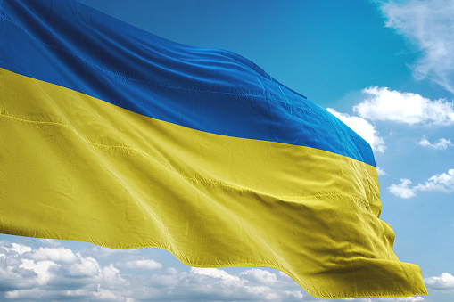Bandera de Ucrania que agita el fondo de cielo nublado photo