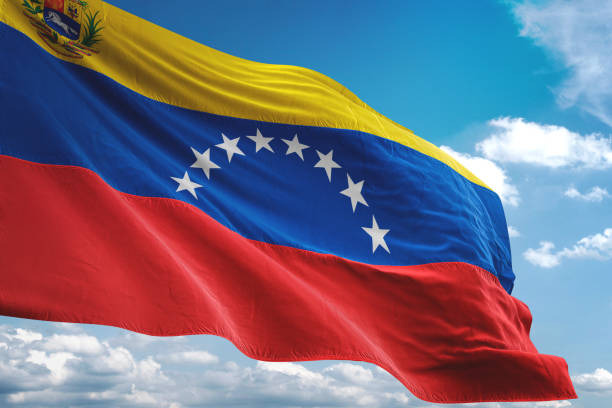 venezuela with coat of arms flag waving cloudy sky background - venezuelan flag imagens e fotografias de stock