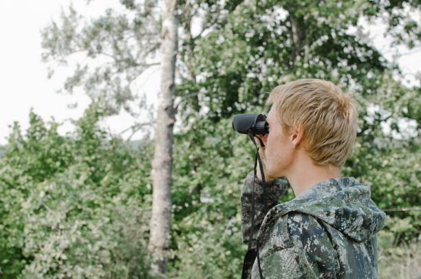 istock young tourist man looking through binoculars into the distance 1069764952
