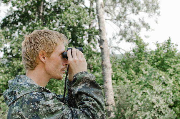 istock young tourist man looking through binoculars into the distance 1069764980