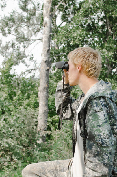 istock young tourist man looking through binoculars into the distance 1069765308