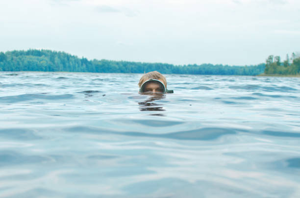 istock man in a mask for snorkeling swims with his head above the water surface 1069767476