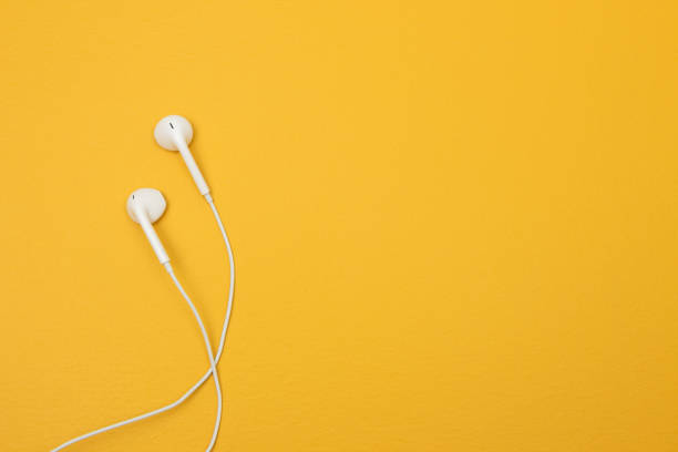 istock White earphones on yellow background with space for text 1069771166