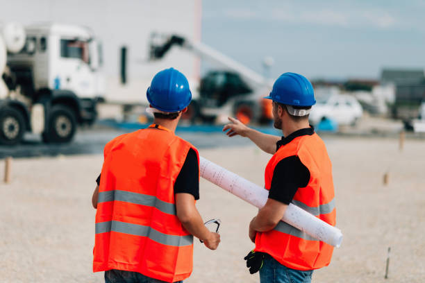 istock Rear View Of Construction Workers Talking Outdoors 1069775118
