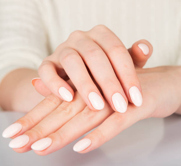 istock Beautiful female hand with beige nail design. 1069776164