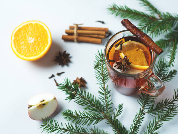 istock Winter warming mulled wine with spices and orange slice and Apple with Christmas tree branches 1069783210