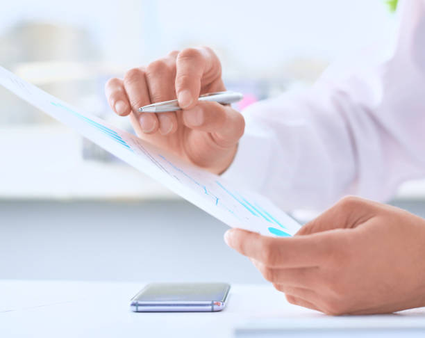 istock Serious business man working on documents and makes notes with a pen close-up. 1069786726