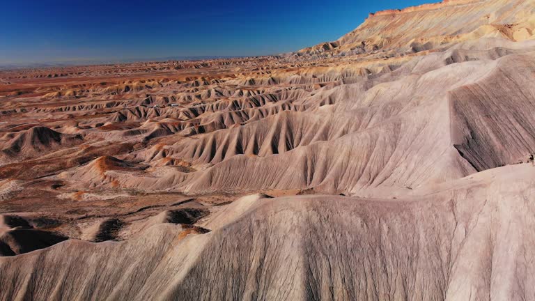 Aerial Drone Shot of the Striped, Eroded Sandstone Cliffs of the Bookcliffs (Geological Formation) and Mt. Garfield in the High Desert of Grand Junction and Palisade, Colorado Against a Vibrant Blue Sky