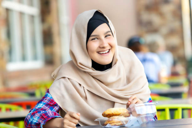 istock Smiling young muslim woman having lunch 1069788658