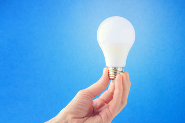 istock LED lamp in hand on a blue background. Concept of the idea 1069790708